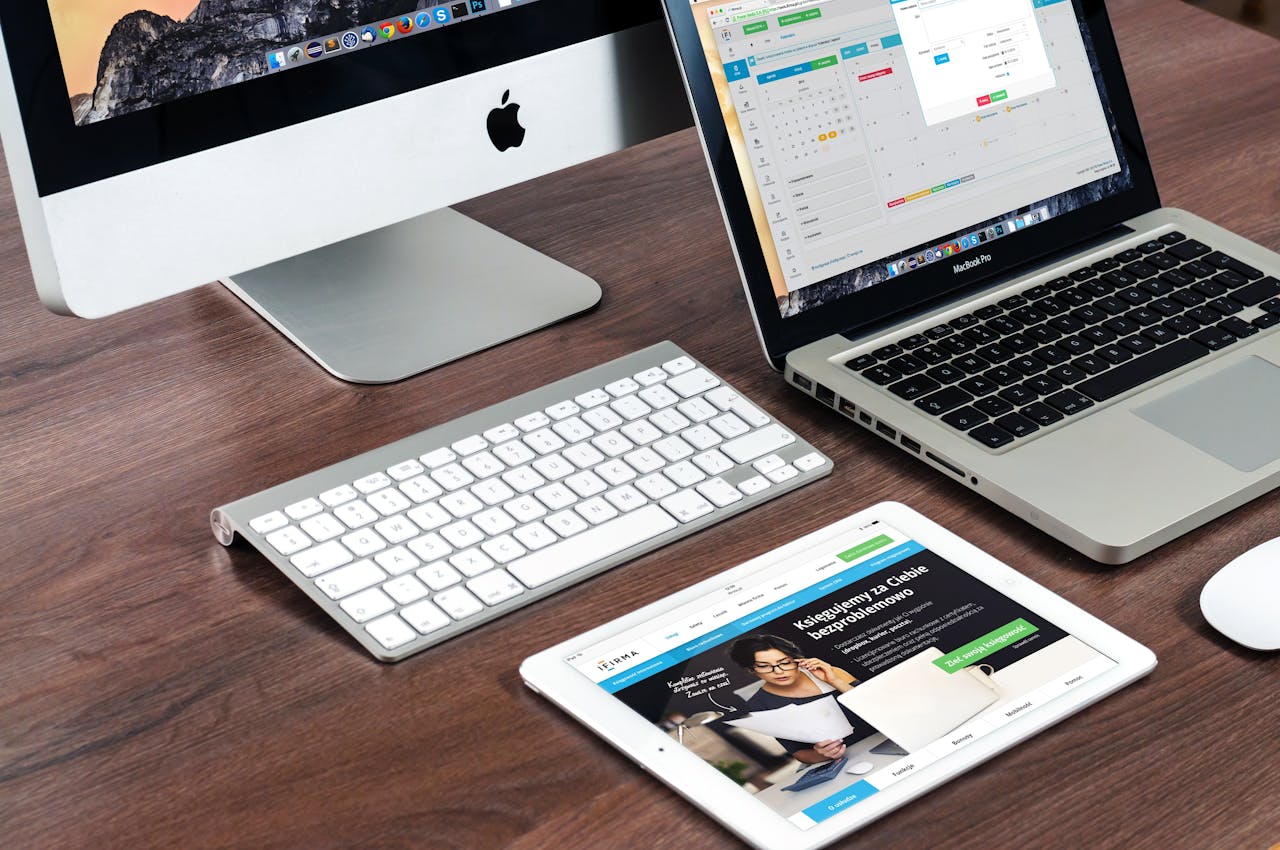 Home A sleek office desk setup featuring Apple devices: iMac, MacBook, and iPad.